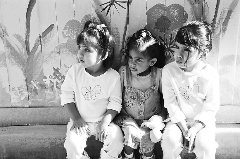 Three young girls sitting on a bench